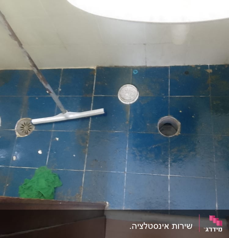 רצפת חדר אמבטיה עם ניקוז פתוח וכלי עבודה